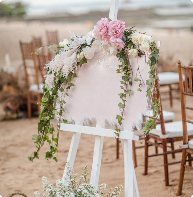 Ceremony chairs dressed with lush florals at an outdoor wedding